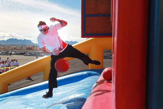 A participant gets knocked off an obstacle by a moving panel during the Hit and Run 5k Saturday, March 1, 2014 at Sam Boyd Stadium. The Hit and Run 5k, a fun run with various obstacles to navigate, is being held or planned in two dozen cities across the country.
